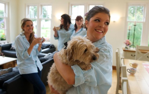 Photo of bride on the morning of the wedding cuddling her dog