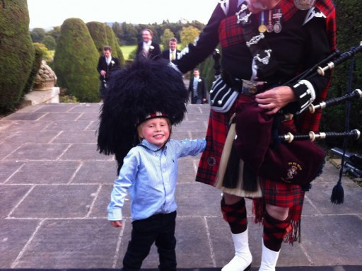 Photo of a little boy at a Scottish wedding with a piper wearing full Highland regalia