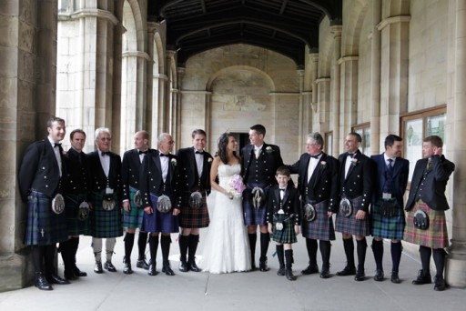 Photo of bride and groom with kilted wedding guests