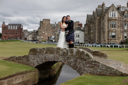 Photo of bride and groom standing on the Swilcan Bridge on the Old Course in St Andrews