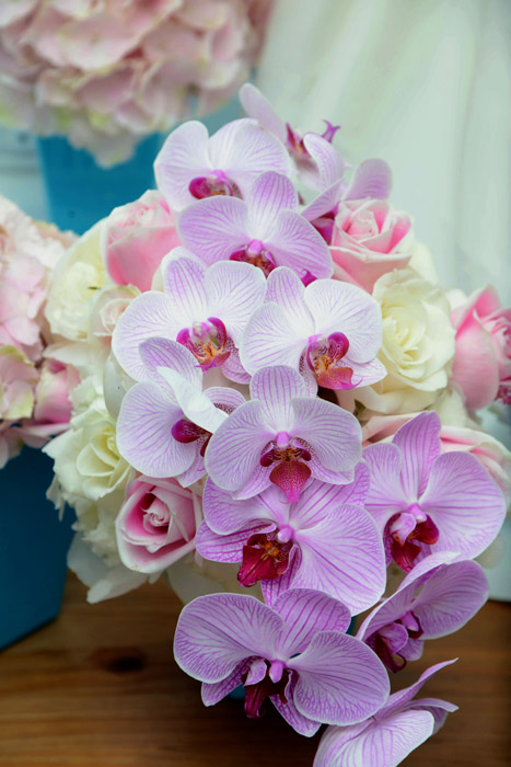 Photo of wedding bouquet with lilac orchids and ivory roses