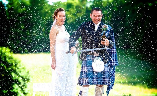 Photo of bride and groom outside spraying champagne