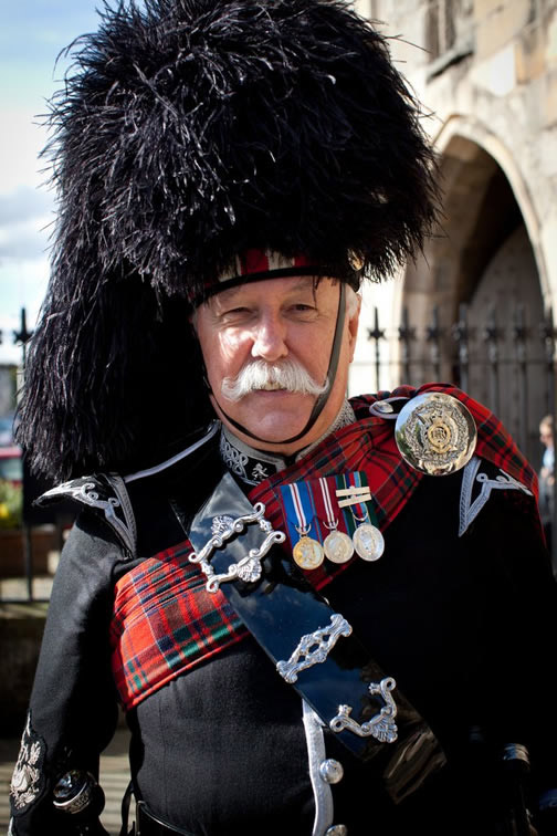 Photo of a pipe band member dressed in full Highland regalia