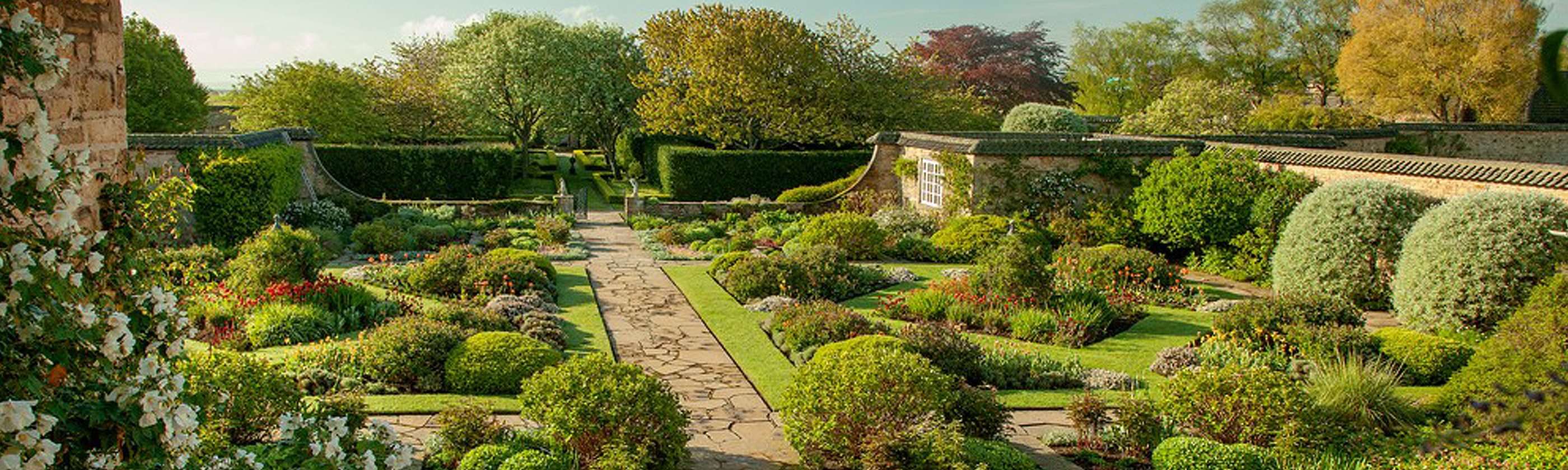 Photo of formal walled gardens at Greywalls Hotel, with herbaceous borders and geometric flowerbeds.