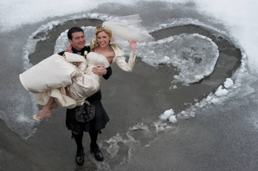 Photo of groom carrying bride in the snow
