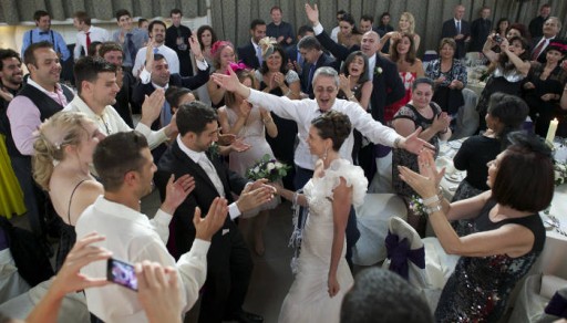 Bride and groom being welcomed to their wedding reception by their guests